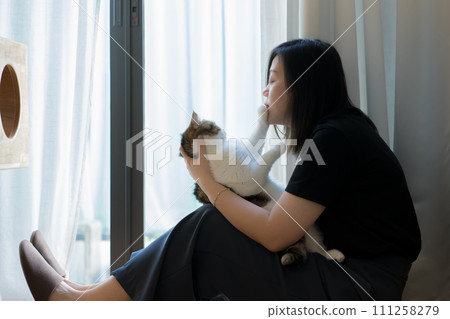 wellness and wellbeing concept with asian woman sit and play with her cat in livingroom wellness and wellbeing concept with asian woman sit and play with her cat in livingroom 111258279