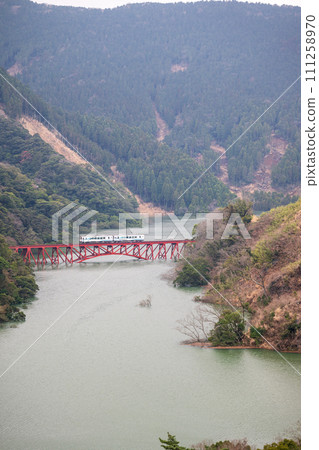 Fully flooded Tateno Dam and Minamiaso Railway iron bridge 111258970