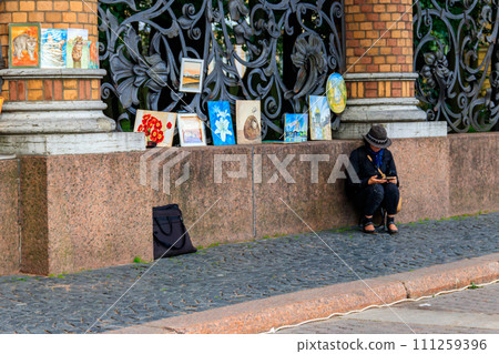 Woman painter sale her pictures near Church of the Saviour on the Spilled Blood in Saint Petersburg, Russia Woman painter sale her pictures near Church of the Saviour on the Spilled Blood in Saint Petersburg, Russia 111259396