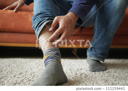 man suffering from itching skin on feet  111259441