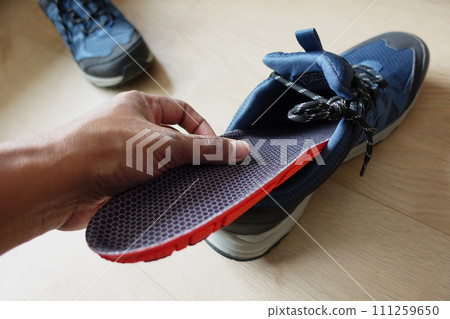 men hand putting Orthopedic insoles in shoes  111259650