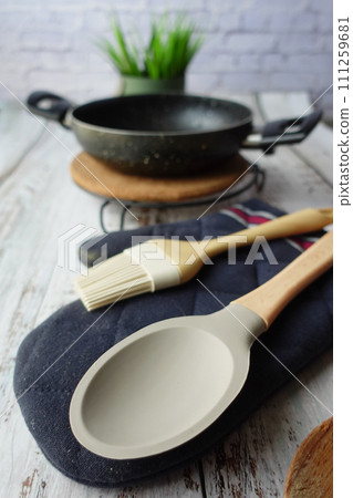 wooden cutlery fork and spoon and cooking pan on table wooden cutlery fork and spoon and cooking pan on table 111259681