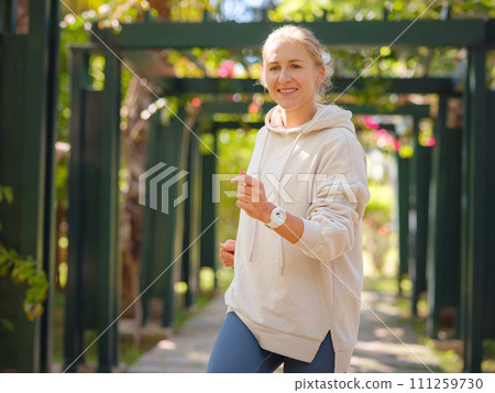 idea of healthy lifestyle and sports in a modern city. Female jogger. Fit young Caucasian woman running in park and enjoying healthy outdoor. Fitness girl in public park. idea of healthy lifestyle and sports in a modern city. Female jogger. Fit young Caucasian woman running in park and enjoying healthy outdoor. Fitness girl in public park. 111259730