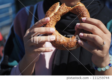 women holding a Turkish Bagel Simit outdoor  111259744