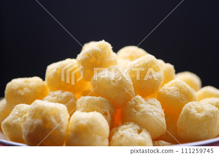 puffed corn rings chips on black background 111259745