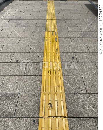 Yellow Braille block for disabled person on footpath no people, leading line on the walkway 111259865
