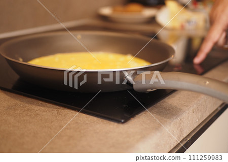 cooking pan on electric stove, electric stove is heated to red.  111259983