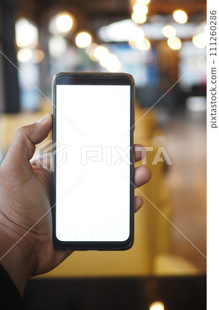 young man hand using smart phone with green screen at cafe  111260286