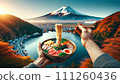 Chopsticks delicately hold ramen noodles over a soup lake, offering a stunning view of Mount Fuji.  111260436