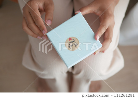 hand putting a thank you sticker on a gift box hand putting a thank you sticker on a gift box 111261291
