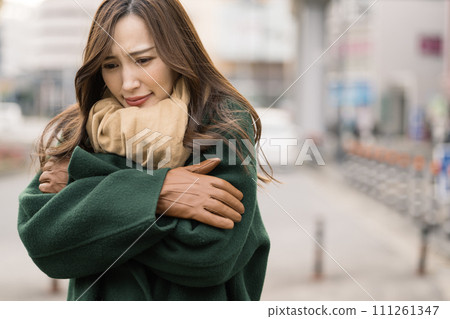 Freezing young woman waiting outside in the cold 111261347