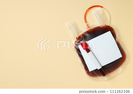 Bag and test tube with donor blood on beige background, space for text Bag and test tube with donor blood on beige background, space for text 111262106