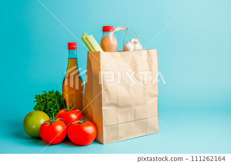 Craft brown shopping paper bag and grocery on blue background. Delivery concept Craft brown shopping paper bag and grocery on blue background. Delivery concept 111262164