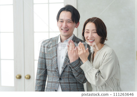 Smiling couple showing their wedding rings 111263646