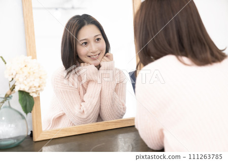 一個女人托著下巴照鏡子 111263785