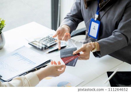 Employees present with mock up credit card payments to business customers. Ready to provide discounts and life insurance Employees present with mock up credit card payments to business customers. Ready to provide discounts and life insurance 111264652