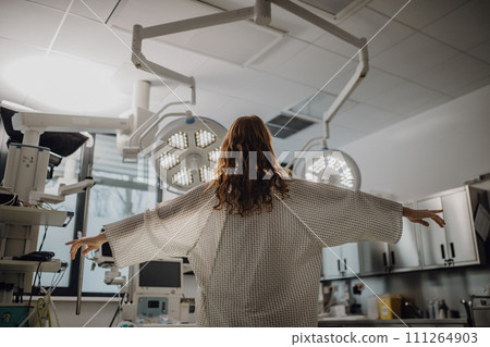 Rear view of patient in hospital gown in emergency room. Looking like angel. 111264903
