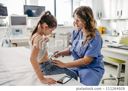 Nurse injecting insulin in diabetic girl belly. Close up of young girl with type 1 diabetes taking insuling with syringe needle. Nurse injecting insulin in diabetic girl belly. Close up of young girl with type 1 diabetes taking insuling with syringe needle. 111264926