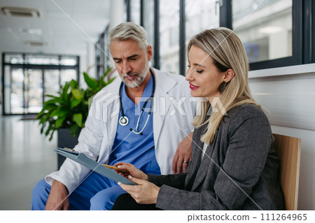 Pharmaceutical sales representative talking with doctor in medical building. Ambitious female medical rep presenting new medication. Female hospital director with medical director. 111264965
