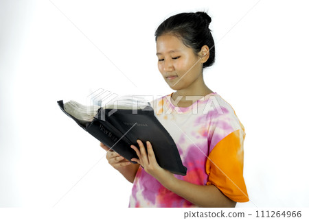 Christian young Asian girl holds the bible in hands. Reading the Holy Bible. concept of faith and spirituality. 111264966