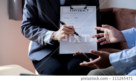 The real estate agent explains the business contract, rent, purchase, mortgage, a loan, or home insurance to the women buyer The real estate agent explains the business contract, rent, purchase, mortgage, a loan, or home insurance to the women buyer 111265471