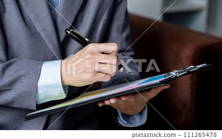 Businesswoman bookkeeper hand holding pen and use calculator, laptop analysis the graph for Setting challenging business goals and ready to achieve target at home office 111265478