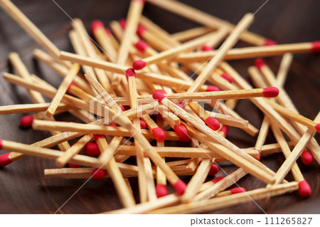 Matchsticks pile with red sulfur in household wooden bowl close up. Matchsticks pile with red sulfur in household wooden bowl close up. 111265827