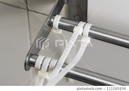 Attached plastic cable ties on a metal detail. Close up 111265834