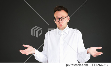 Uncertain shrug. No idea. Doubt ignorance. Clueless overwhelmed careless smart guy raising shoulders isolated on dark black empty space background. Uncertain shrug. No idea. Doubt ignorance. Clueless overwhelmed careless smart guy raising shoulders isolated on dark black empty space background. 111266087