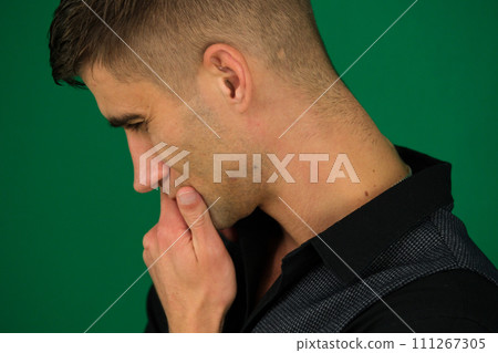 serious business man in profile on a light background emotions of a handsome man guy on a green background chromakey close-up dark hair young man serious business man in profile on a light background emotions of a handsome man guy on a green background chromakey close-up dark hair young man 111267305