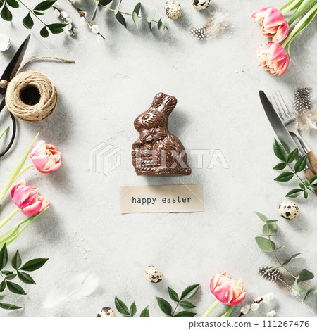 Easter Chocolate Bunny spring flowers and cutlery on light grey background 111267476