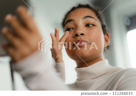 Portrait of beautiful curvy woman, sitting on bed, holding her hair, looking at camera. Portrait of beautiful curvy woman, sitting on bed, holding her hair, looking at camera. 111268033
