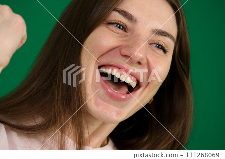 A pretty women throws her head back in a big laugh. A pretty women throws her head back in a big laugh. 111268069