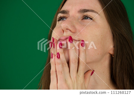 Portrait of afraid screaming young woman different emotions of a young girl on a green background chromakey beautiful facial features real people pink T-shirt white skinned. European 111268127