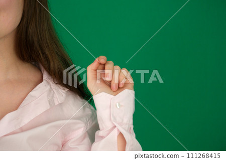 Portrait of young happy beautiful woman smiling and standing isolated on green background in a warm sweater. Young female girl with a perfect smile looking right. 111268415