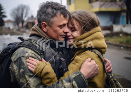 A soldier in camouflage returned home from war and hugs his wife 111268726
