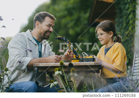 Father supporting daughter in pursuing robotics, science, IT technologies and programming. Concept of young girls in science. 111269188