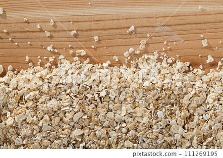 Oat-flakes on wooden surface 111269195
