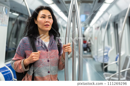 Young woman passenger sitting in subway car 111269296