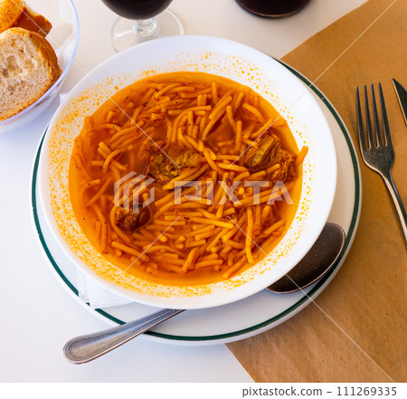 Bowl of traditional catalonian meal Fideos a la cazuela con costilla closeup 111269335