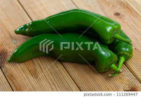 Whole peppers on wooden table Whole peppers on wooden table 111269447