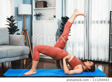 Flexible and dexterity woman in sportswear doing reverse gaiety yoga position 111269483