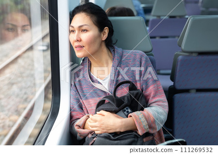 Portrait of a woman traveler with a backpack and a phone in train car 111269532