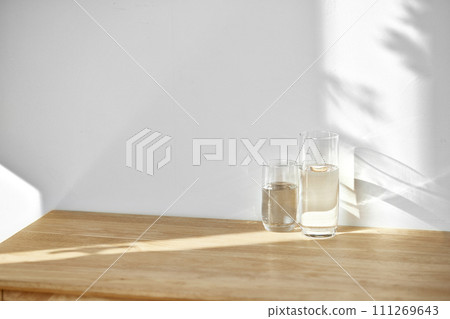 A water cup and shadow on a table in the sunlight. A water cup and shadow on a table in the sunlight. 111269643