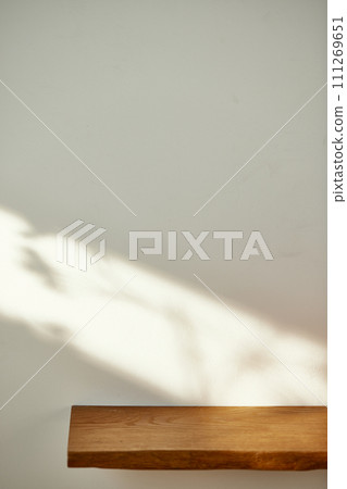 A water cup and shadow on a table in the sunlight. 111269651