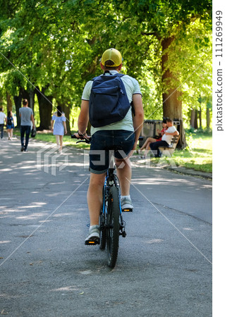 Cyclist spend their time on bicycle in park on sunny day. Ride for exercise and relaxation. Healthy lifestyle. Sport and active life concept. Cyclist spend their time on bicycle in park on sunny day. Ride for exercise and relaxation. Healthy lifestyle. Sport and active life concept. 111269949