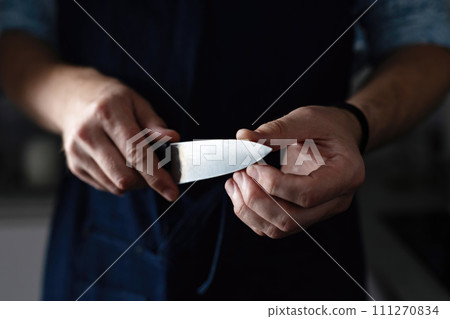 Head Chef Inspects Sharpened Kitchen Knife Closely 111270834