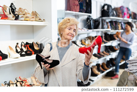 Elderly woman selecting footwear in shoeshop 111272599