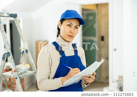 Woman builder checking project documentation 111272601