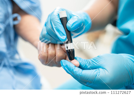 Doctor check diabetes from finger blood sugar level with finger lancet. 111272627